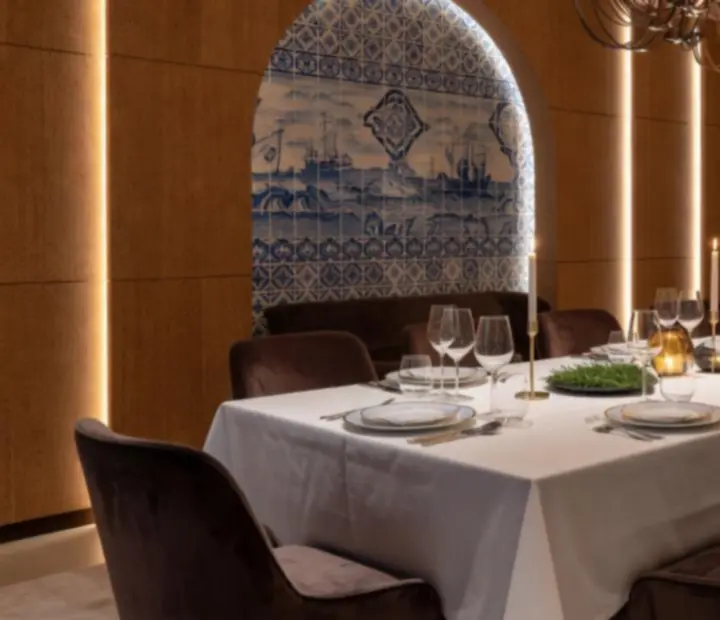 Sala de restaurante de luxo em Lisboa preparada para evento exclusivo com mesas elegantemente decoradas.